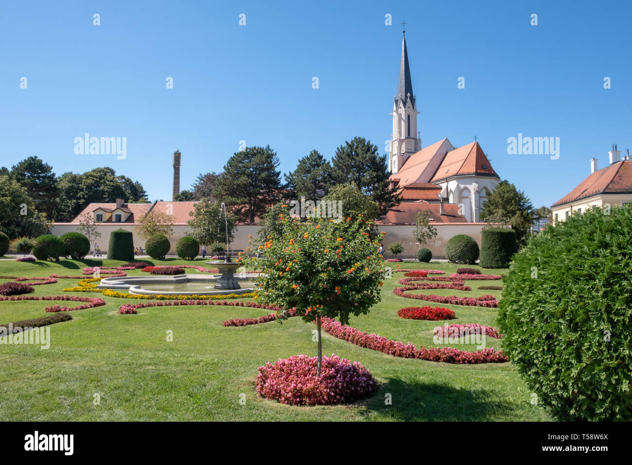 The Palmenhaus Garten at Schloss Schoenbrunn in Vienna, Austria with view of the catholic church Mariae Hilf Stock Photo