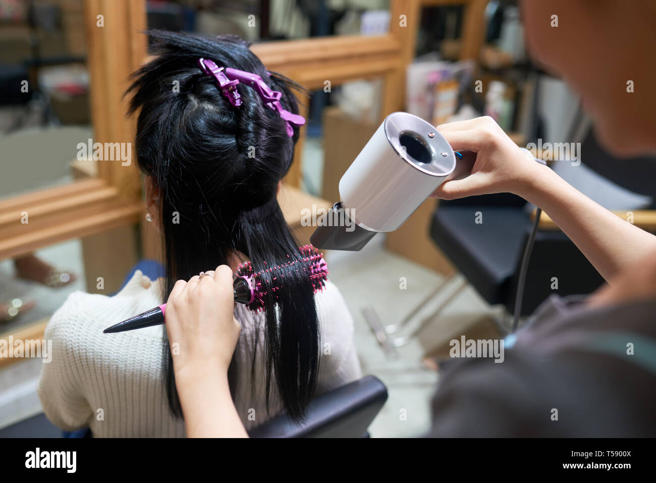 Styling hair using hair dryer Stock Photo Alamy
