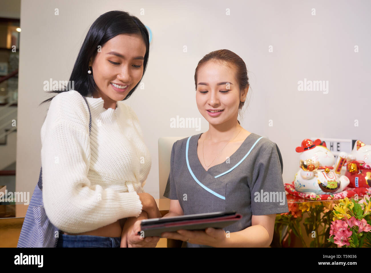Beauty salon specialist consulting Asian client Stock Photo - Alamy