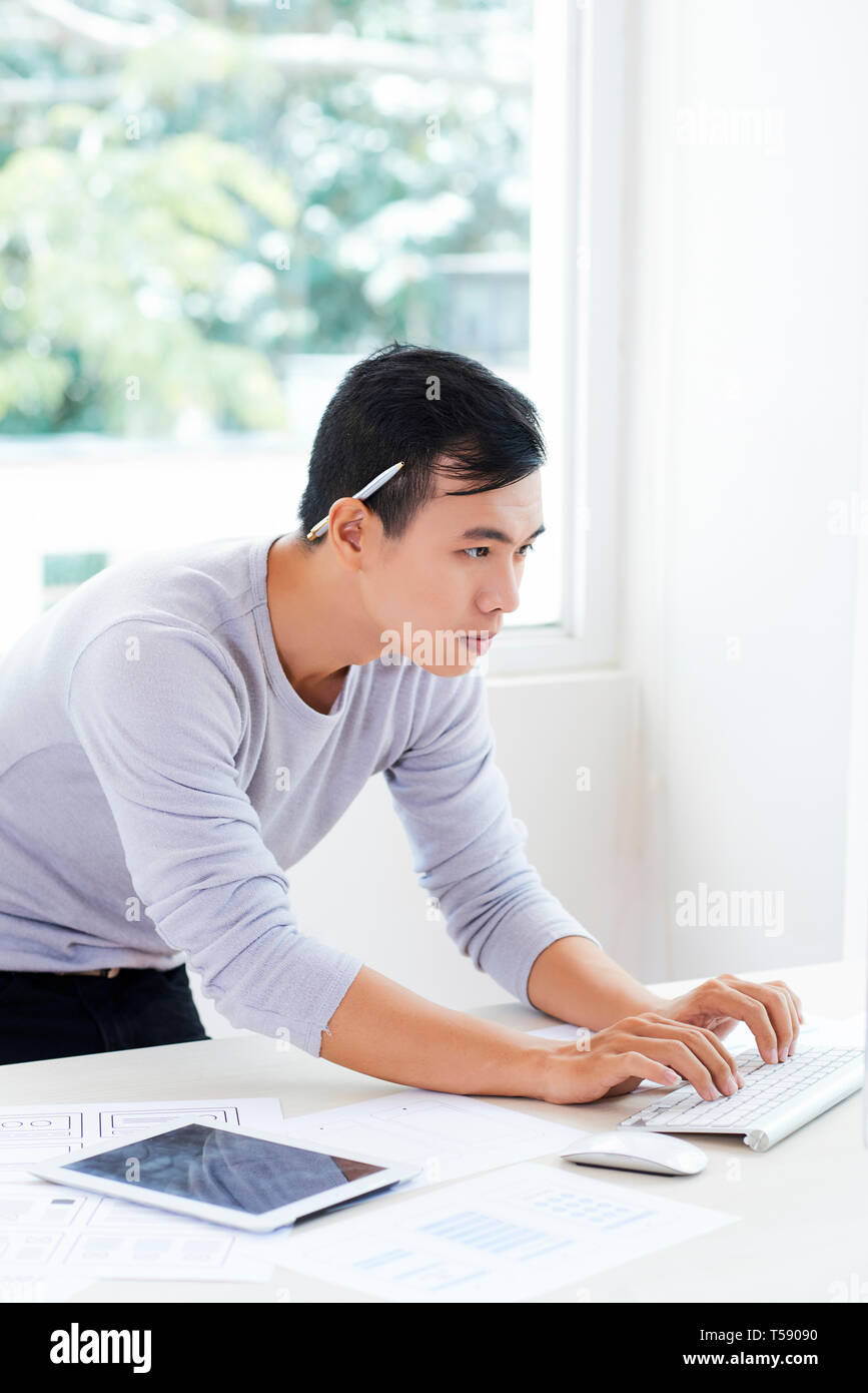 Busy Vietnamese IT engineer coding information Stock Photo