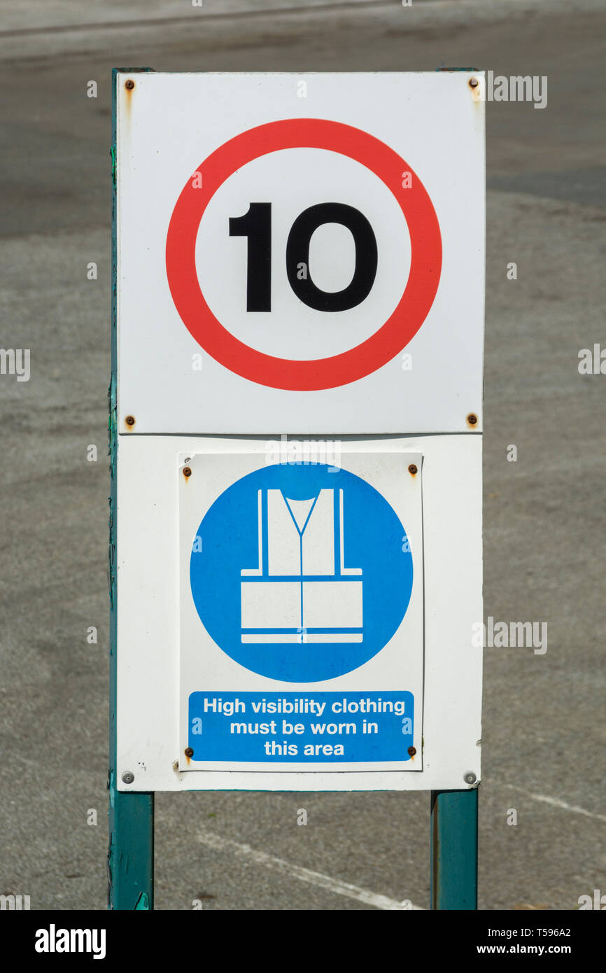 10 MPH vehicle speed sign with High Viz clothing safety sign. Health and safety at work concept, factory warning signs. Stock Photo
