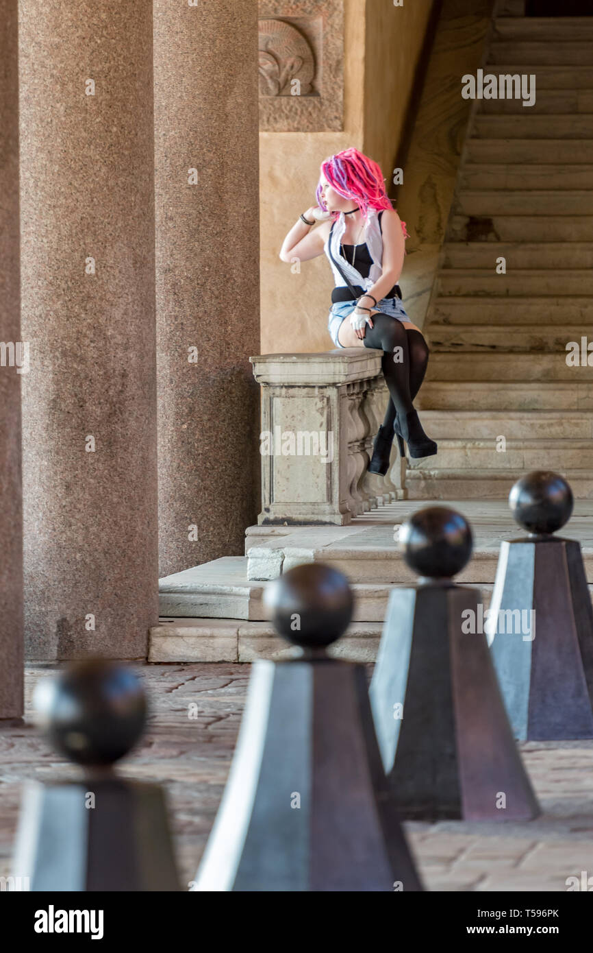 A model with bright pink and purple candyfloss type hair posing at Stockholm City Hall Stock Photo
