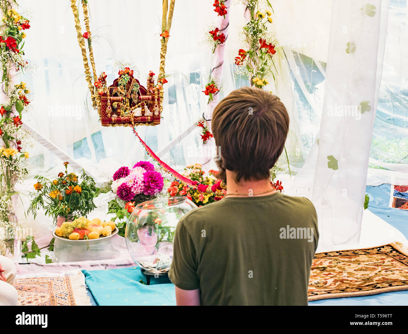 Man gently swing on swing idols of Radha and Krishna statue for begging the blessing on Jhulan Yatra fest it is the biggest and most popular religious Stock Photo