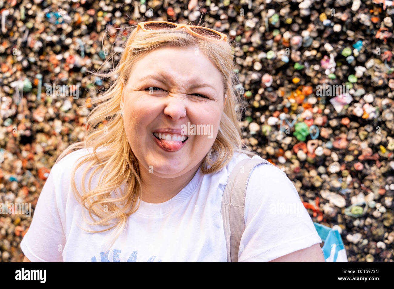 Blonde woman makes a gross face with her tounge out while visiting the Bubblegum Alley wall in San Luis Obispo California Stock Photo