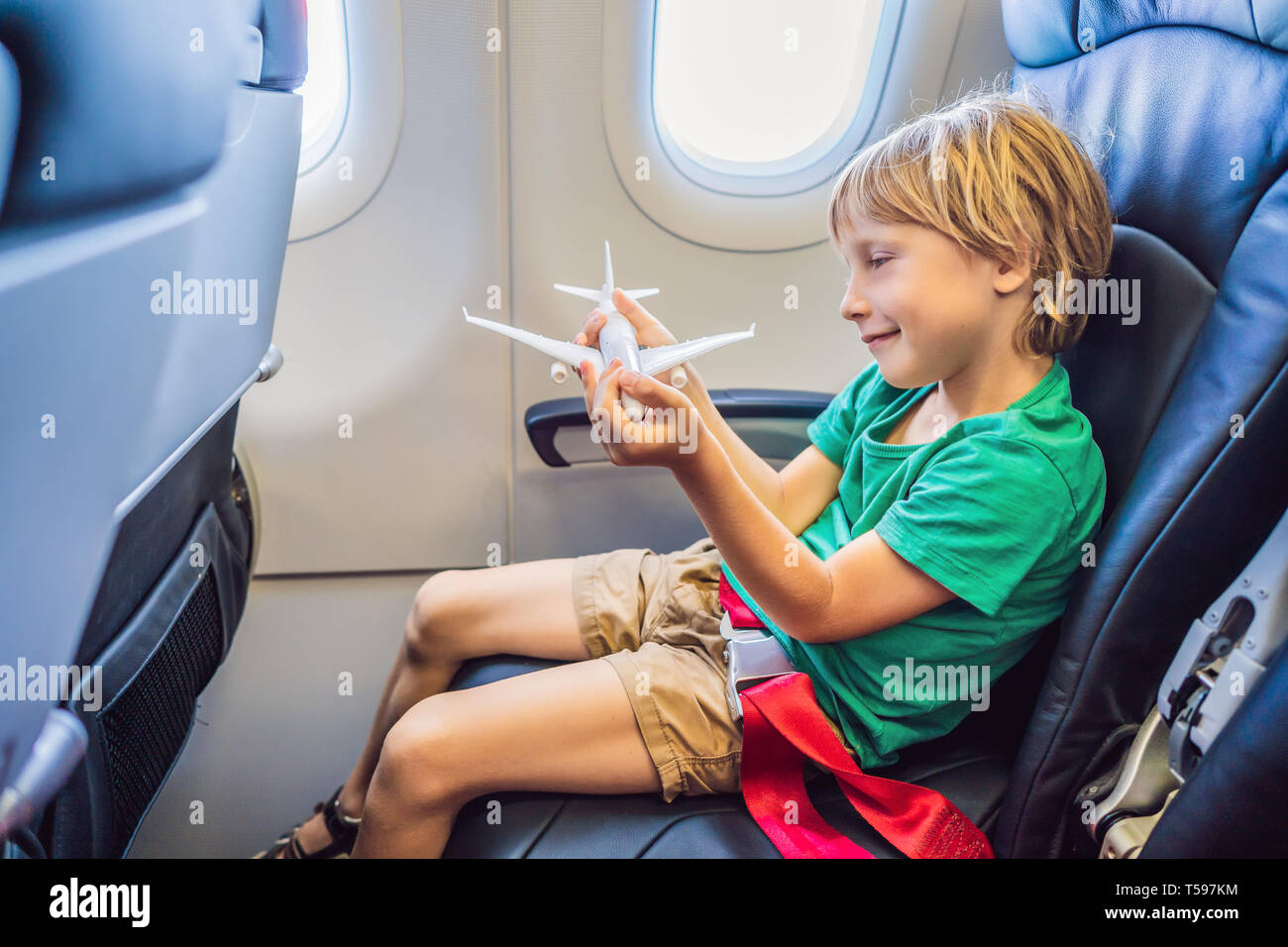 Little boy play with toy plane in the commercial jet airplane flying on vacation Stock Photo Alamy