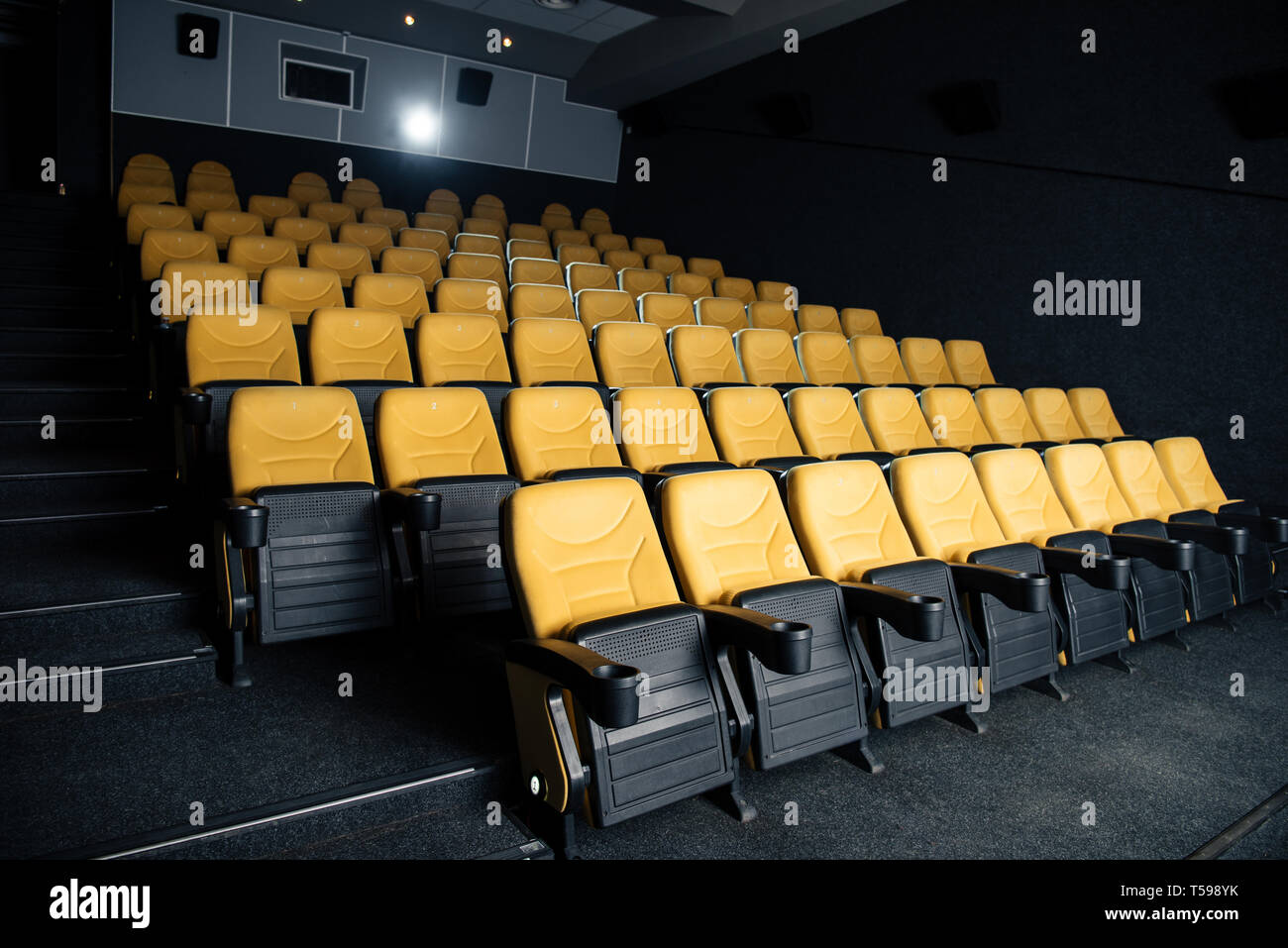 Dark Cinema Hall With Comfortable Empty Seats With Cup Holders