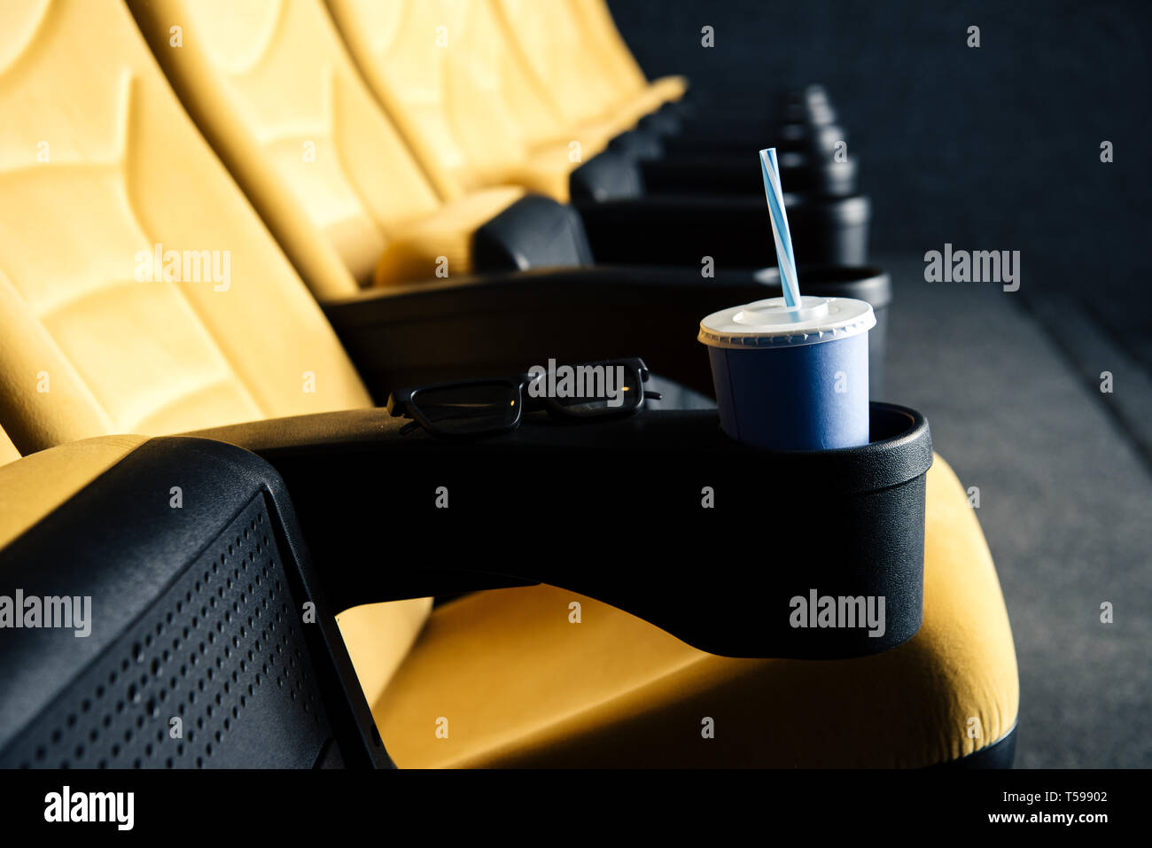 selective focus of orange cinema seats with disposable cup in cup