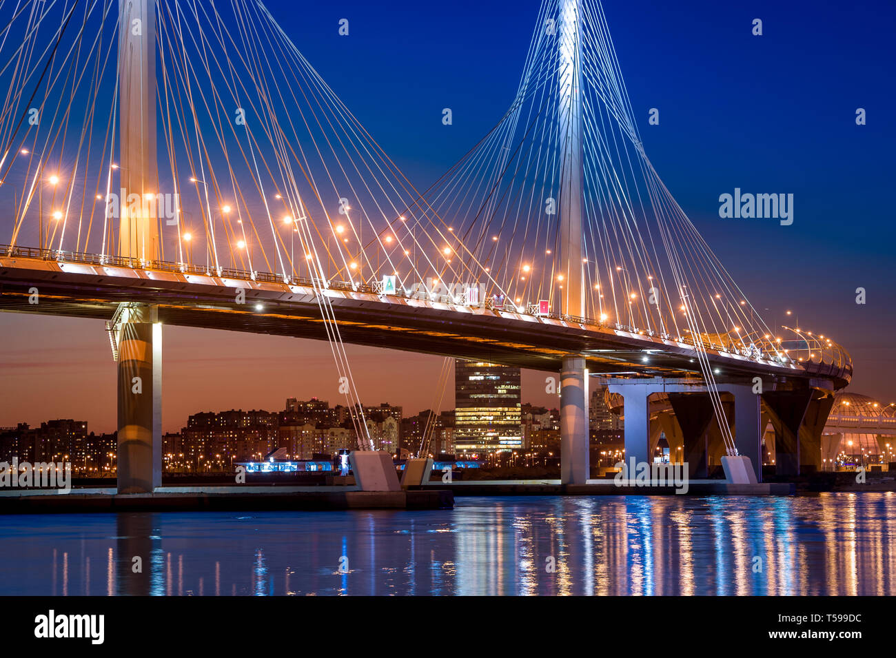 Saint-Petersburg cable bridge night view with sunset color on the horizon, blue sky and bridge lights. Russia. Stock Photo