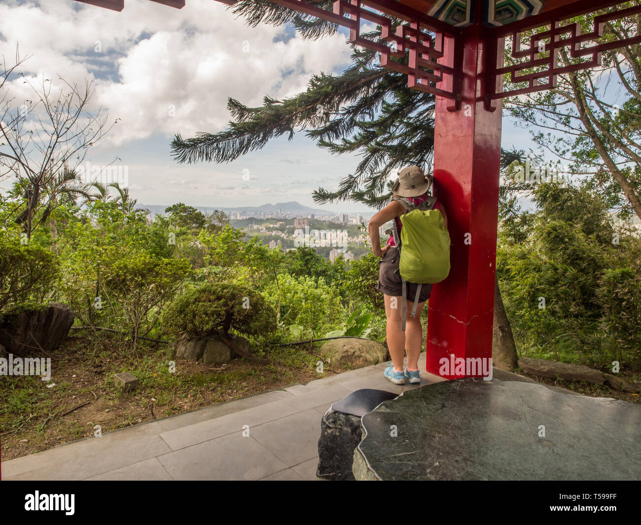 Maokong, Taiwan - October 19, 2016: Women with racksack looking for Taipei City from the park of  the Chih Nan Temple on the hills of Maokong  in Taiw Stock Photo