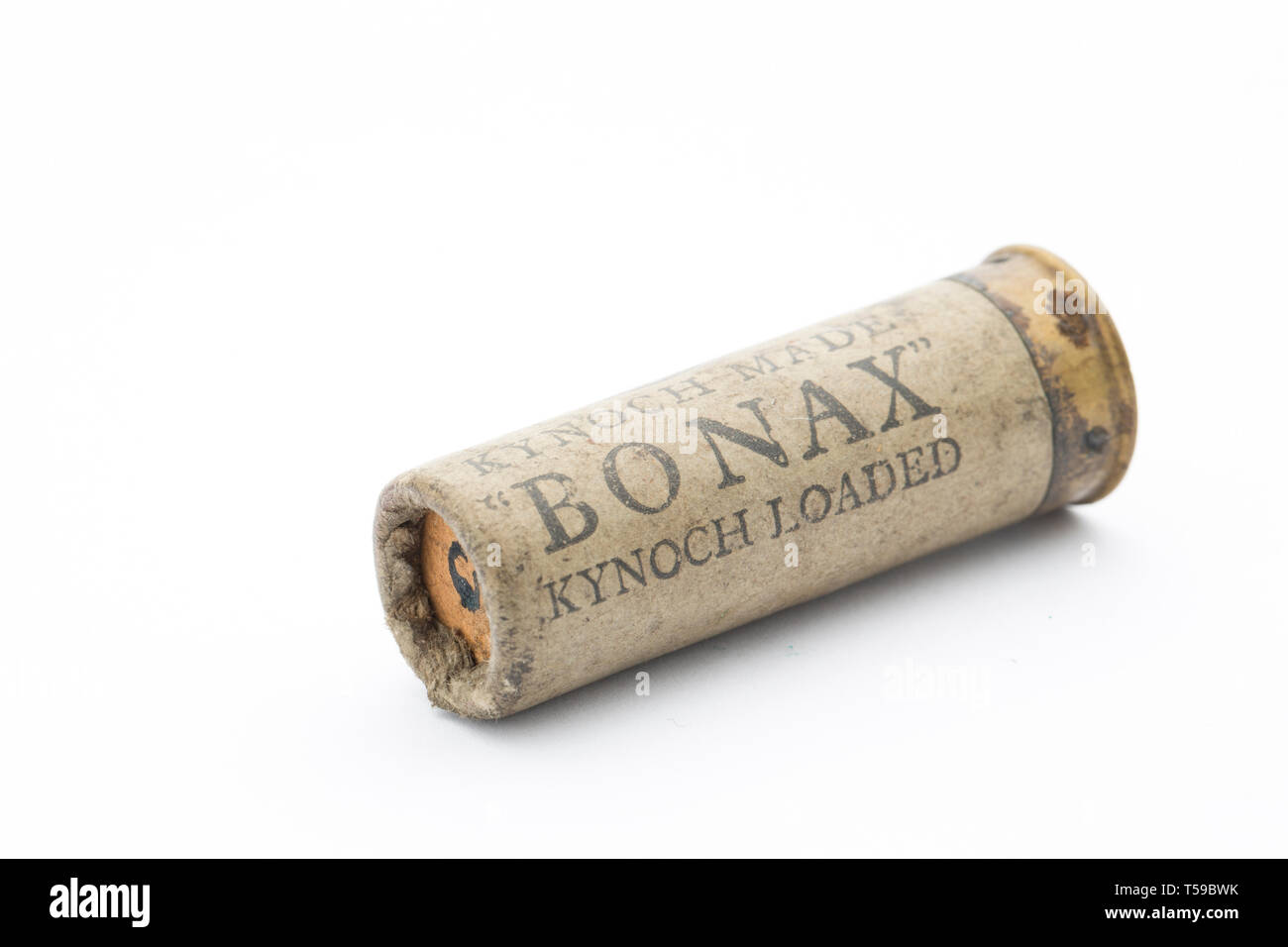 An old Kynoch Bonax paper case 12 gauge shotgun cartridge with a rolled turnover closure loaded with lead shot pellets. Collecting shotgun cartridges  Stock Photo