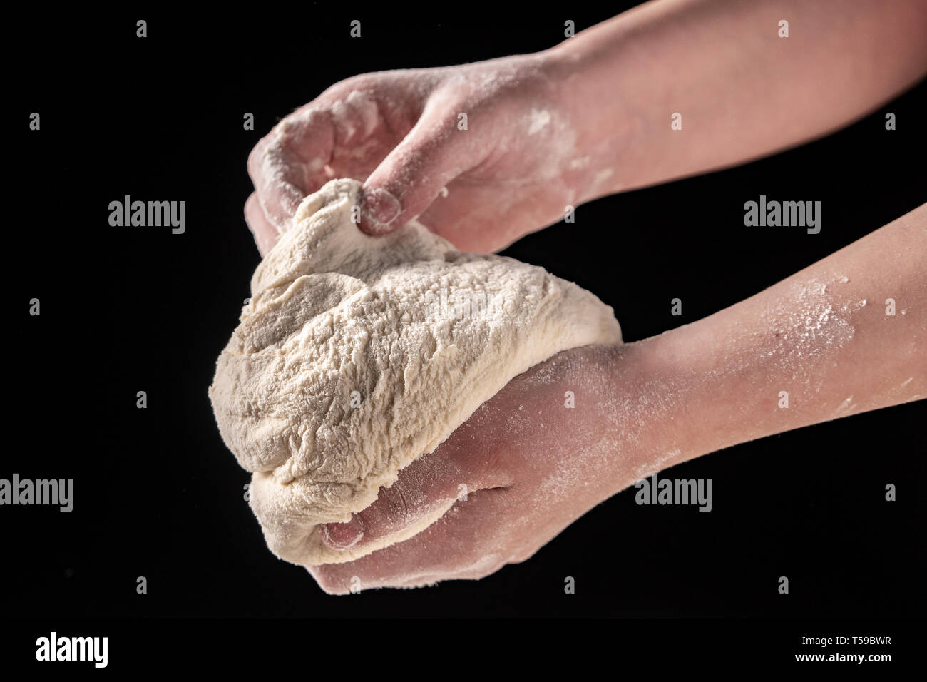 Making dough by female hands at bakery, black background Stock Photo ...