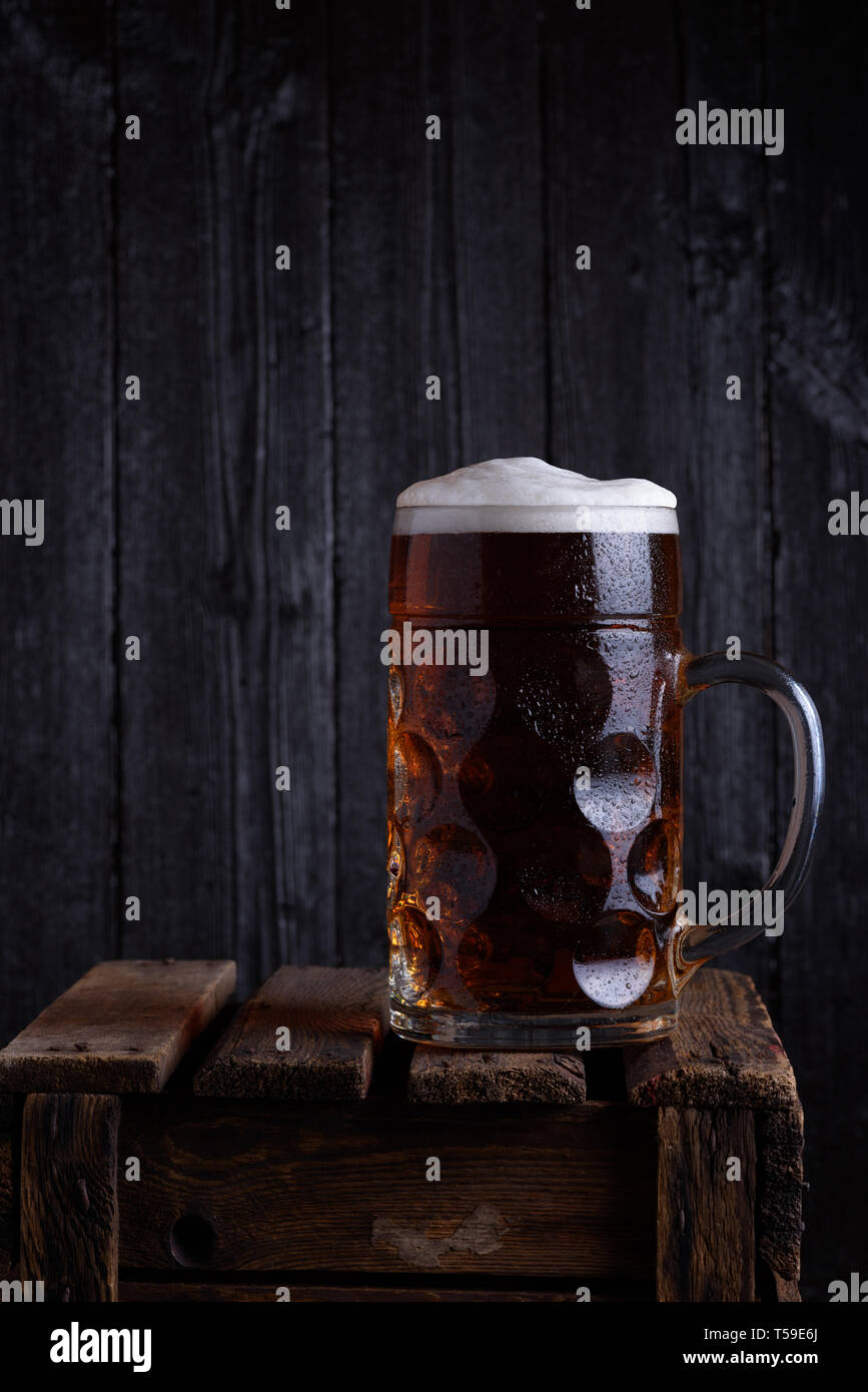 Huge beer mug on vintage wooden crate with dark wooden background still  life Stock Photo - Alamy, image size:867x1390