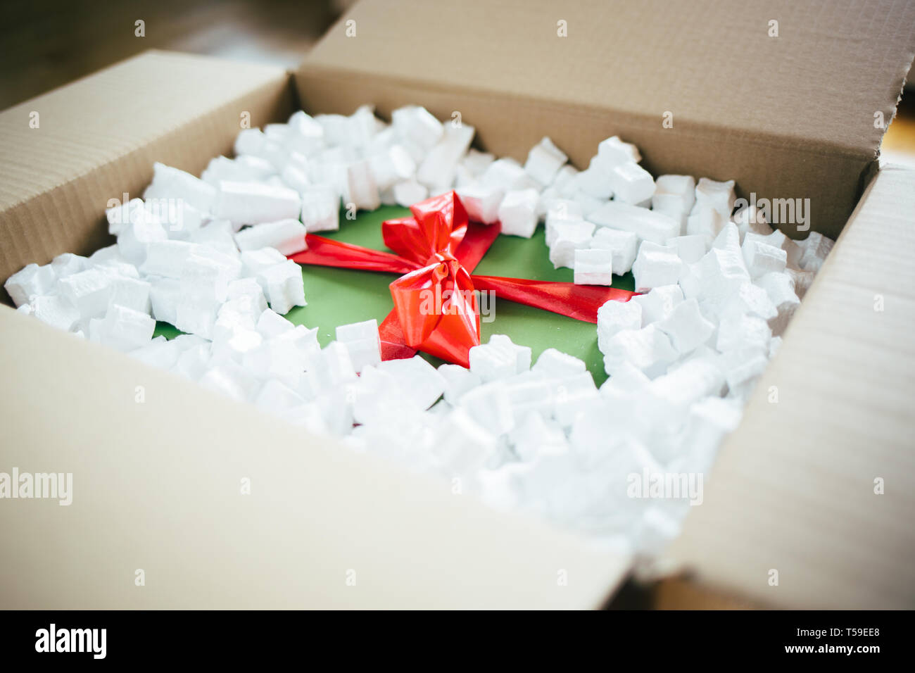Parcel with gift box inside. Open parcel with present inside Stock Photo