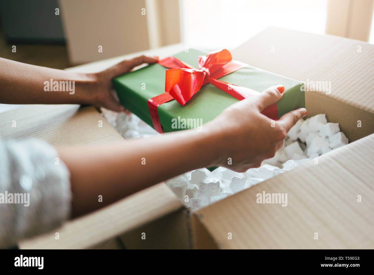 Woman hands opening a parcel contains a gift Stock Photo