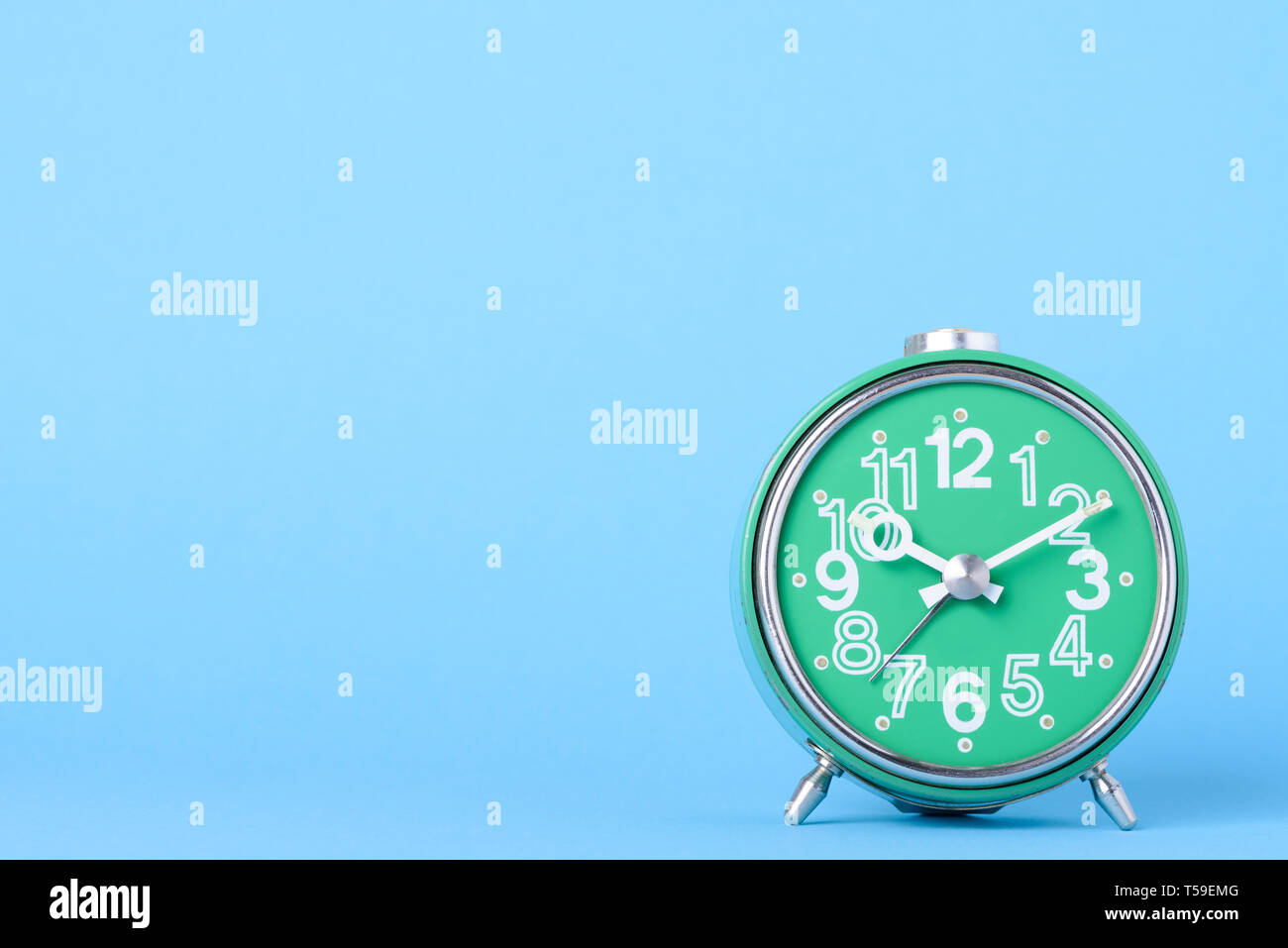 Retro old clock on blue background with copy space Stock Photo - Alamy