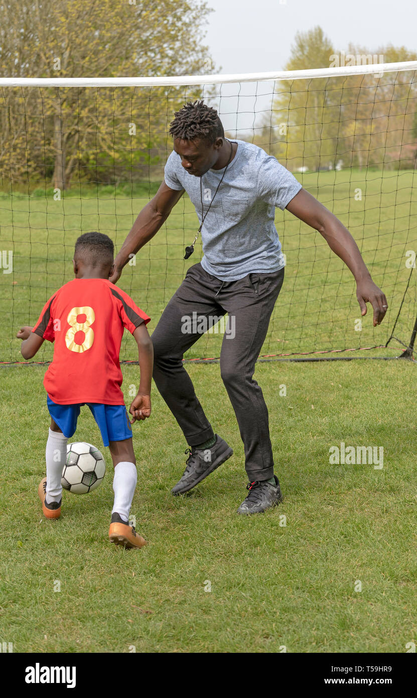 Hampshire, England UK. Aprile 2019. Young soccer player being coached on a football pitch. Stock Photo