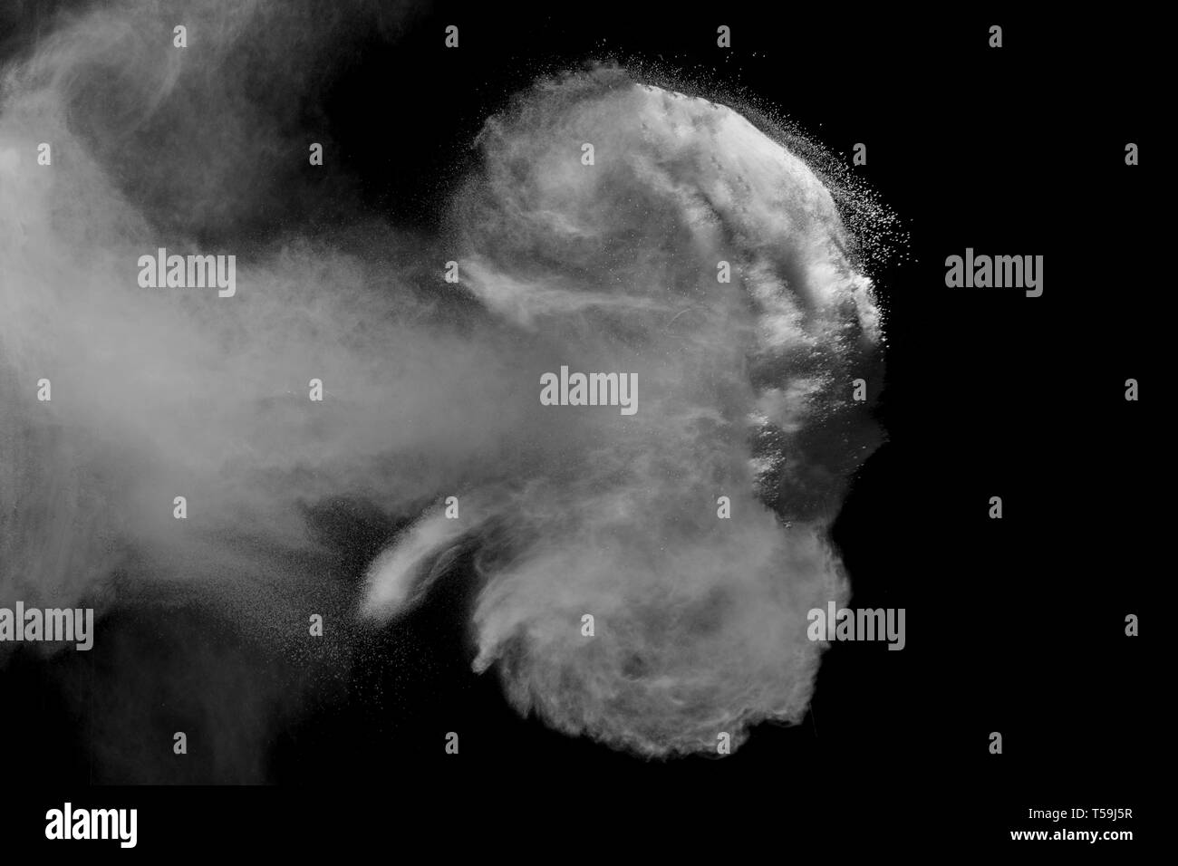White dust particles exhale in the air. Motion powder burst in dark