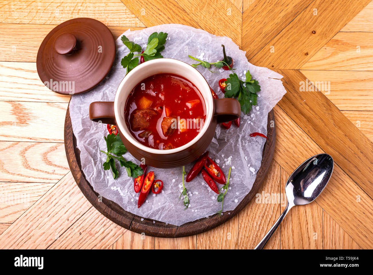 Tasty Hungarian Hot Goulash Soup Bograch or Gulas Lamb Meat Stew on Wooden Surface at Restaurant. Traditional Food. Stock Photo