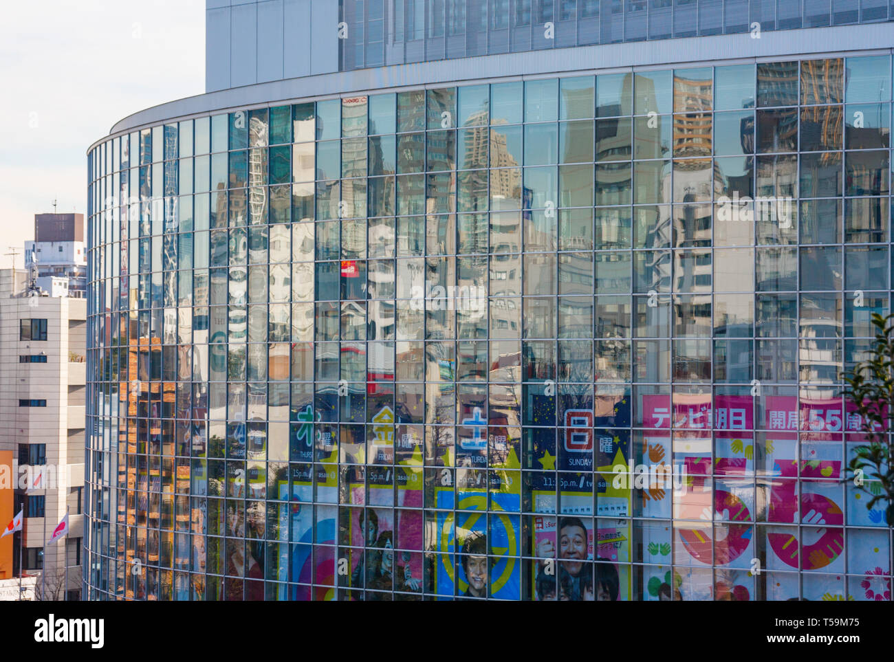 Buildings of the Roppongi district reflecting in the glass facade of TV Asahi headquarters. TV Asahi is a japanese television network. Tokyo, Japan. Stock Photo
