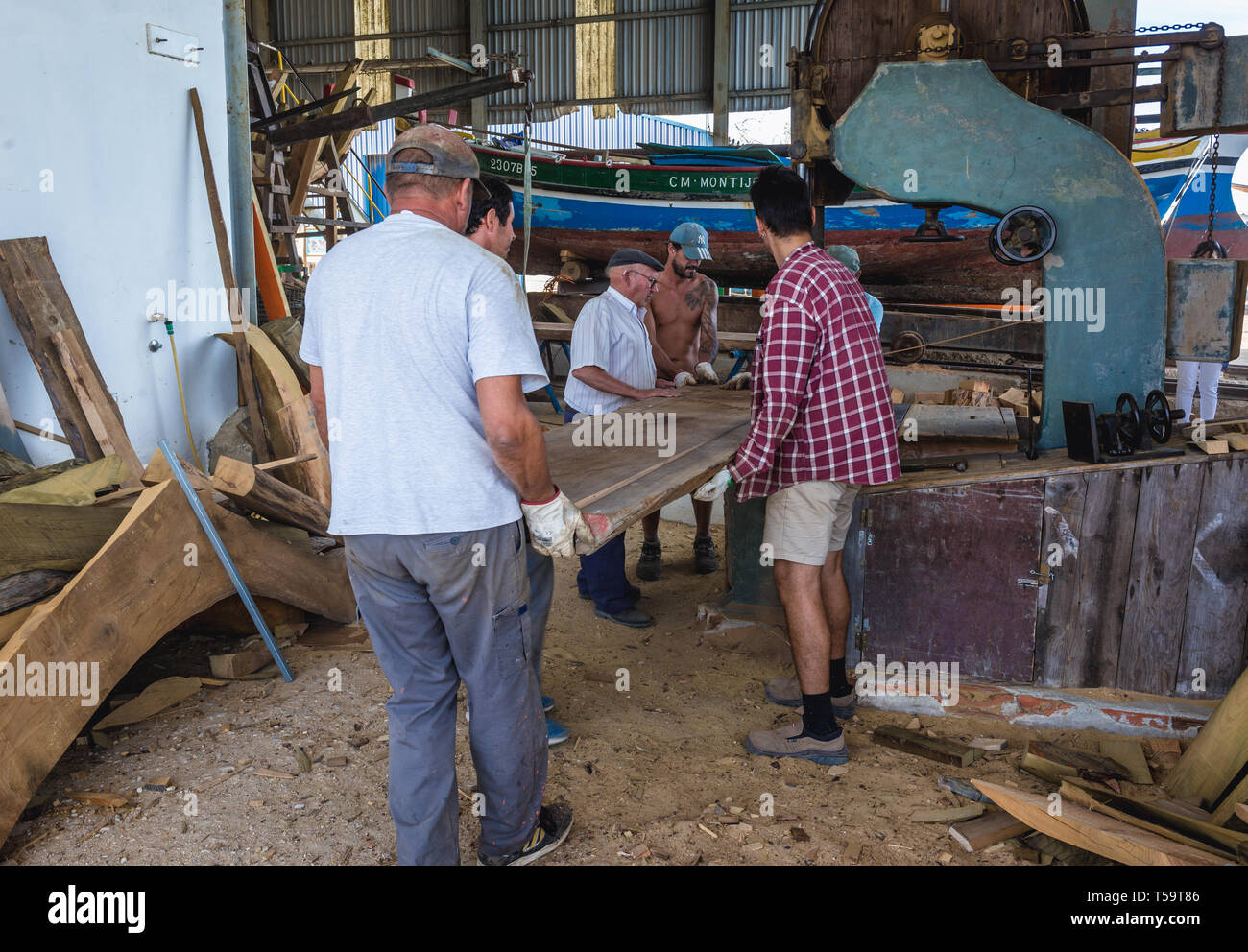 Workers of shipyard in which traditional Tagus River boats are constructed and repaired in Sarilhos Pequenos village in Moita municipality, Portugal Stock Photo