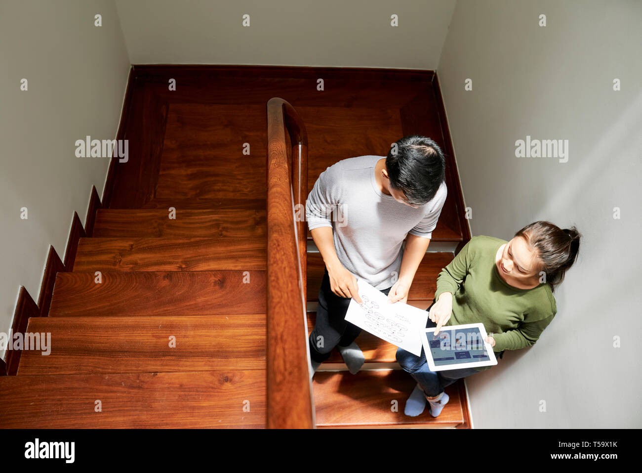 Discussing interface design of application on stairs Stock Photo