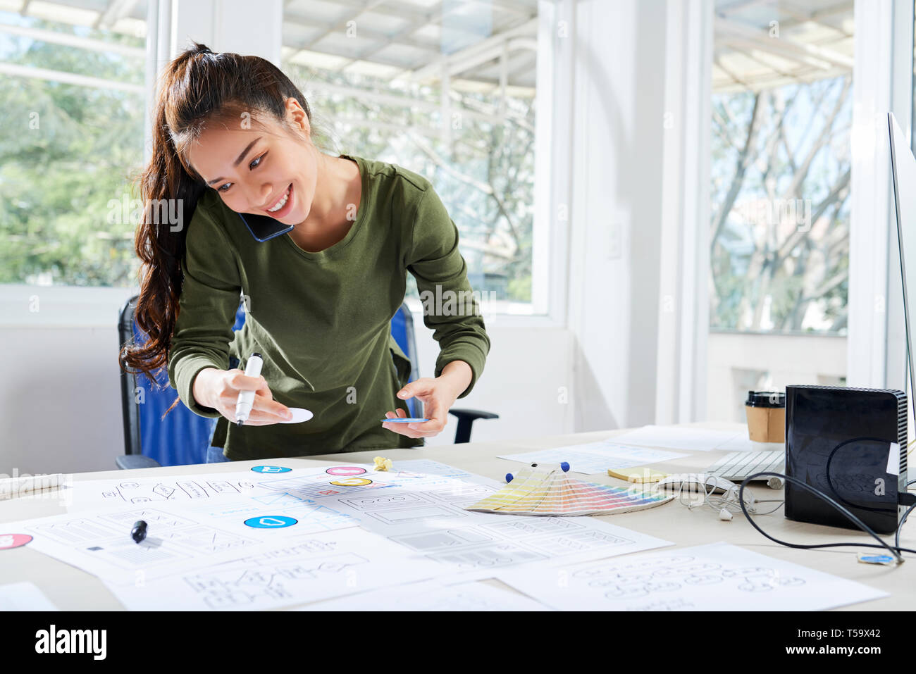 App developer working with sketches while being on phone Stock Photo