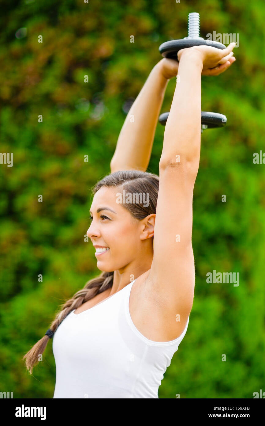 Smiling Pregnant Woman Doing Triceps Extension Exercise In Park Stock