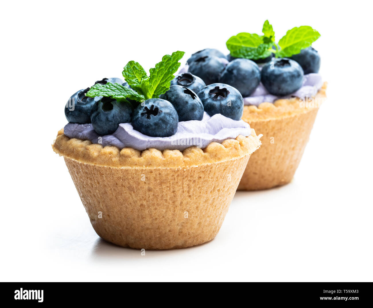 Mini  tarts with blue cream and fresh blueberries isolated on white Stock Photo