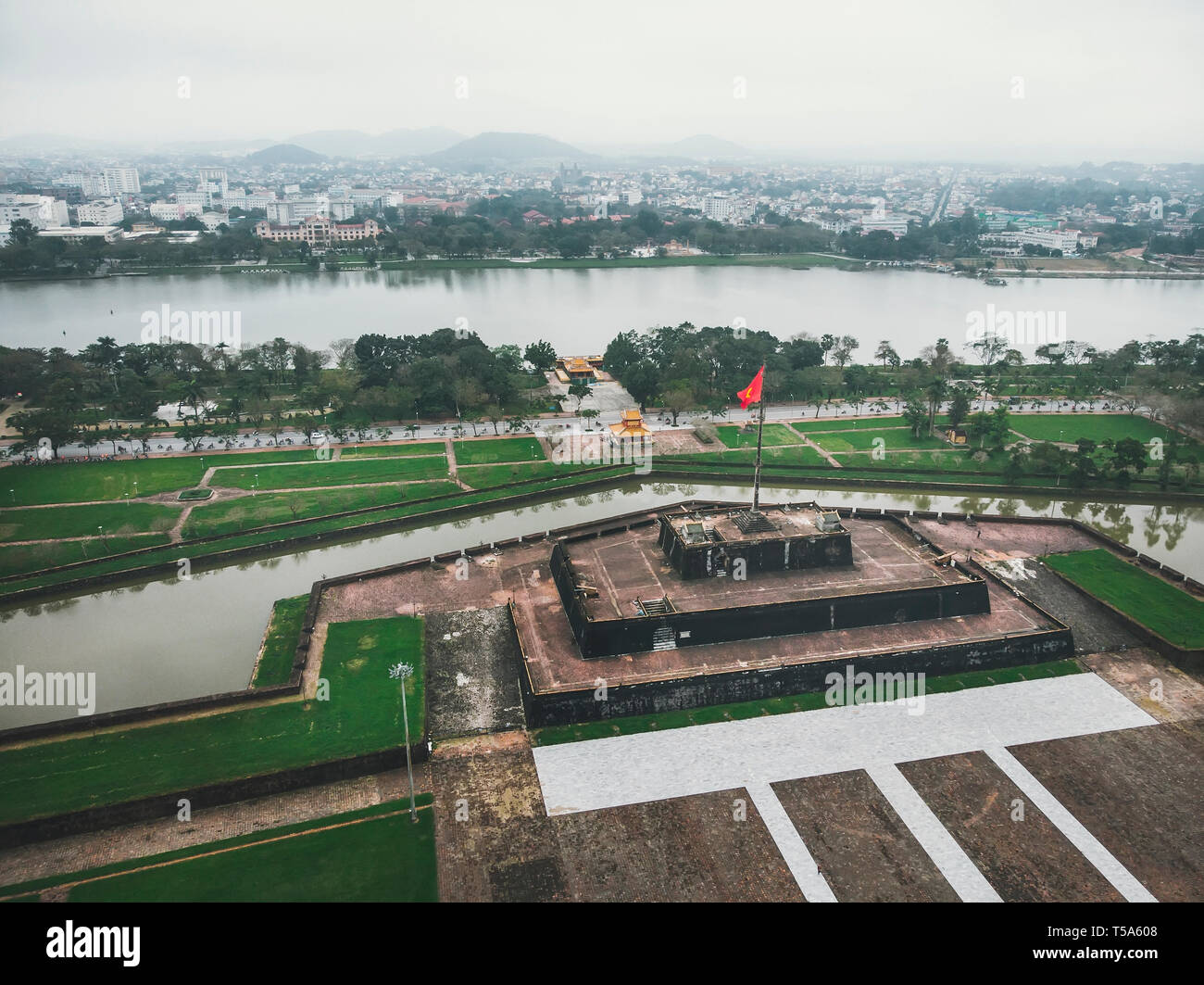The Vietnam flag, waving on top of the stage, in front of the Imperial Palace in Heu, Vietnam. Aerial shot Stock Photo