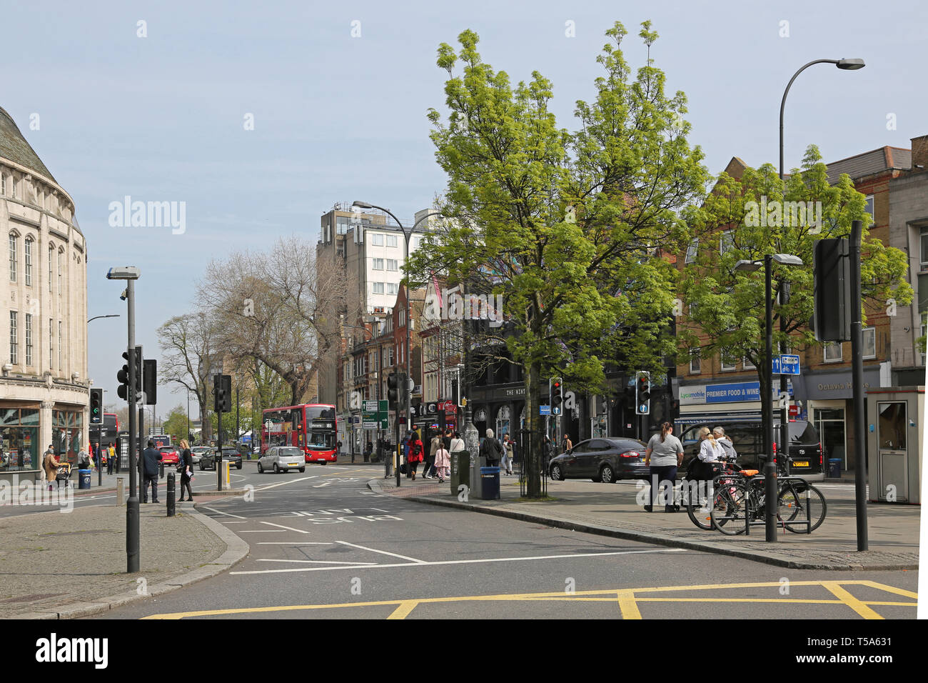 Bus lane in the centre of Catford,South London, UK. Shows shops, traffic lights and pedestrians. Stock Photo