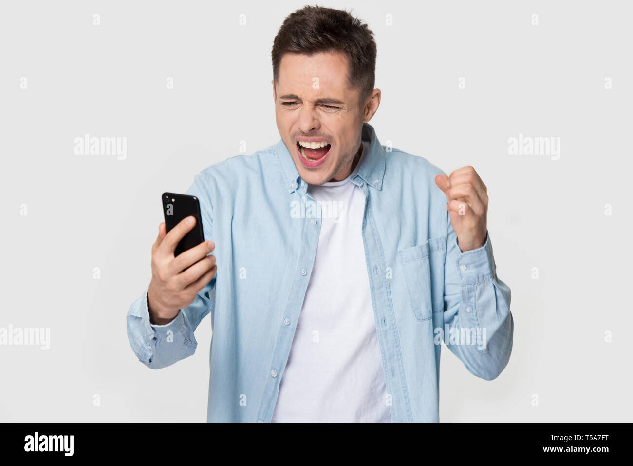 Isolated annoyed Caucasian man scream having cellphone problem Stock Photo