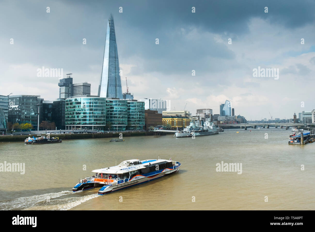 A Thames Clipper river boat on the River Thames with The Shard and other iconic buildings in the background. Stock Photo