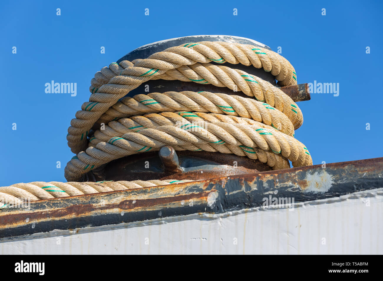 Mooring rope coiled around a bollard at a steel ship Stock Photo