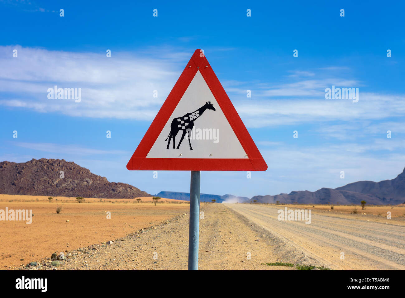 Giraffes crossing warning road sign placed in the desert of Namibia Stock Photo