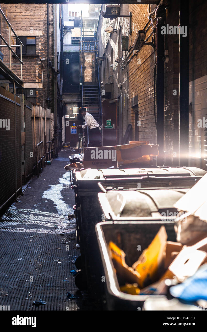 A cook having a fag break in a filthy alleyway, Central London, England, UK. Stock Photo