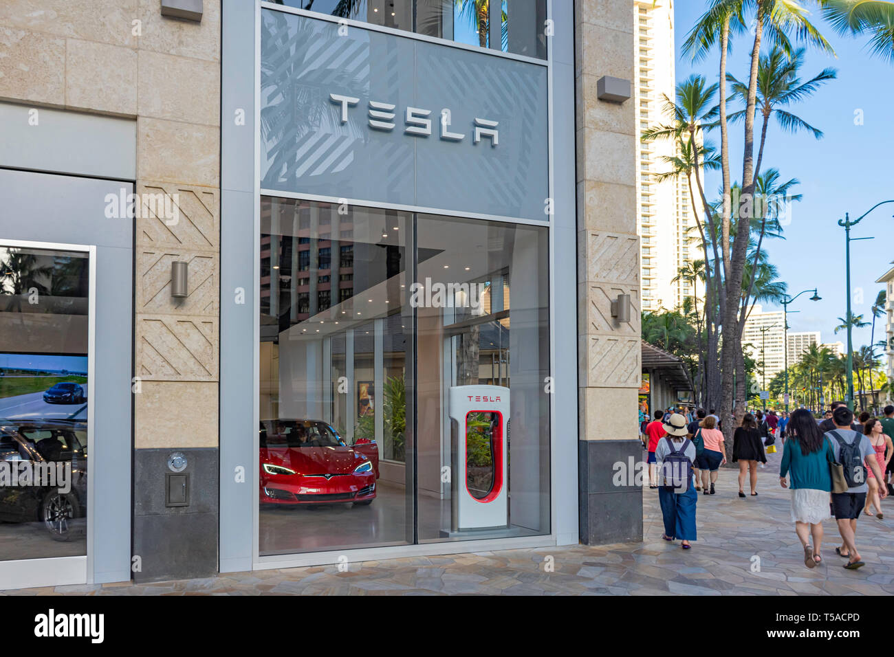 HONOLULU HAWAII USA - APRIL 2, 2019: Tesla Motors showroom in Waikiki Beach with the Tesla Model S in the foreground. Tesla Motors is a designer and m Stock Photo