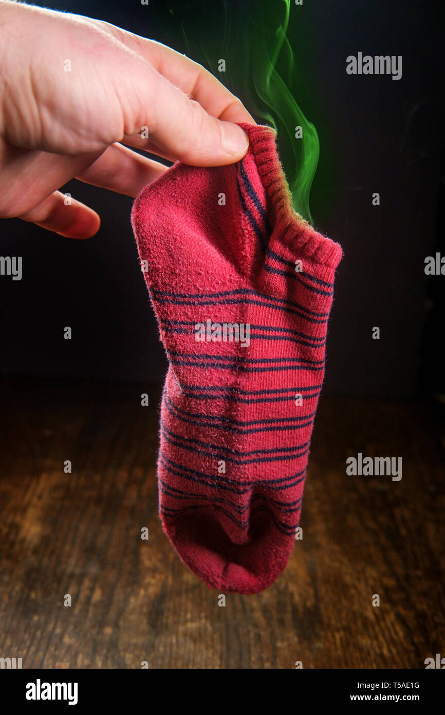 Smelly dirty laundry sock with colorful visible odor vapor Stock Photo