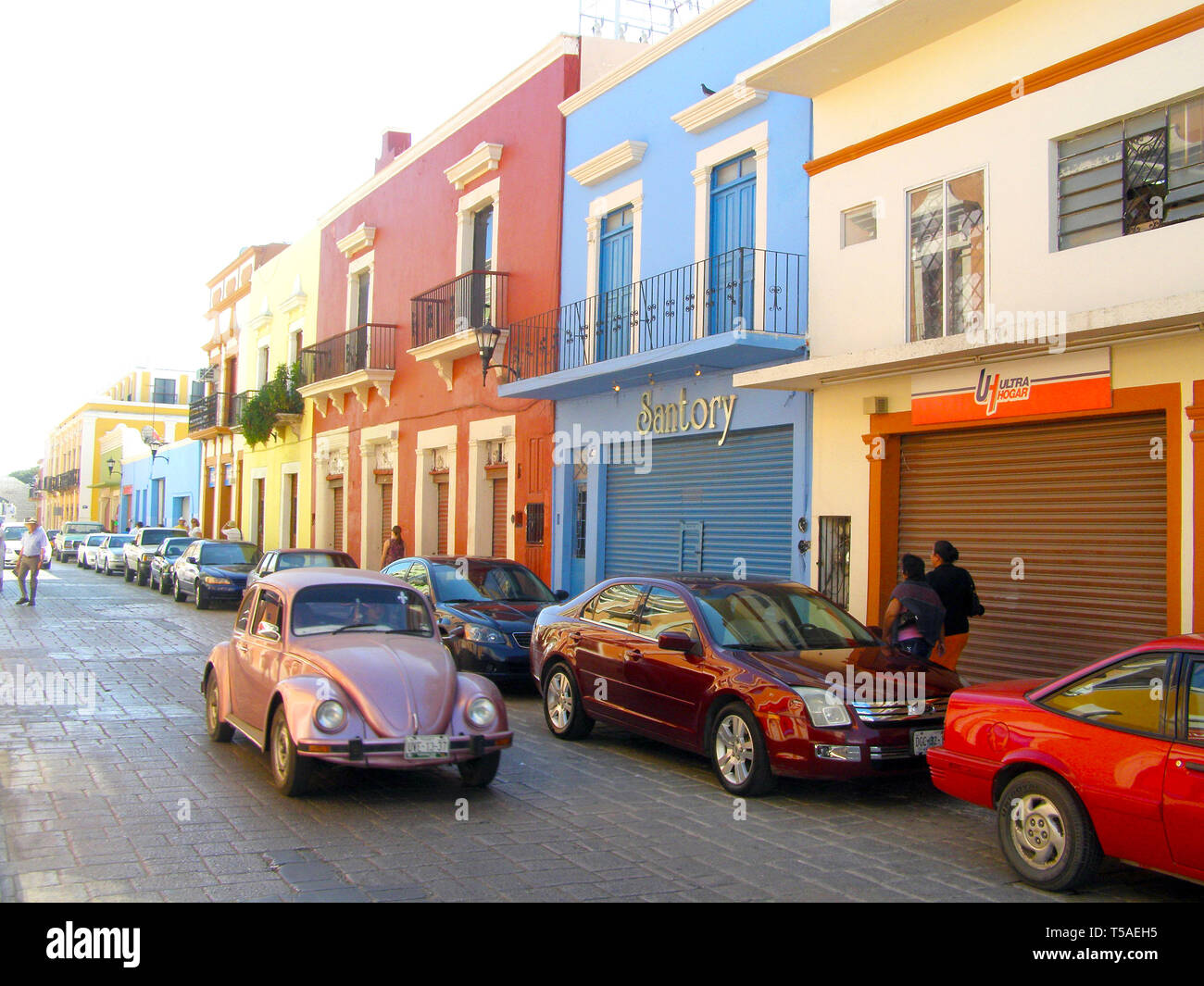 MERIDA, MEXICO 11 th March 2016: Street scene with colorful traditional old houses and old cars on street in Merida on hot sunny day. Big colonial cit Stock Photo