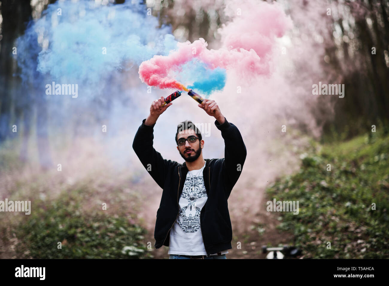 Street style arab man in eyeglasses hold hand flare with red and blue smoke  grenade bomb Stock Photo - Alamy