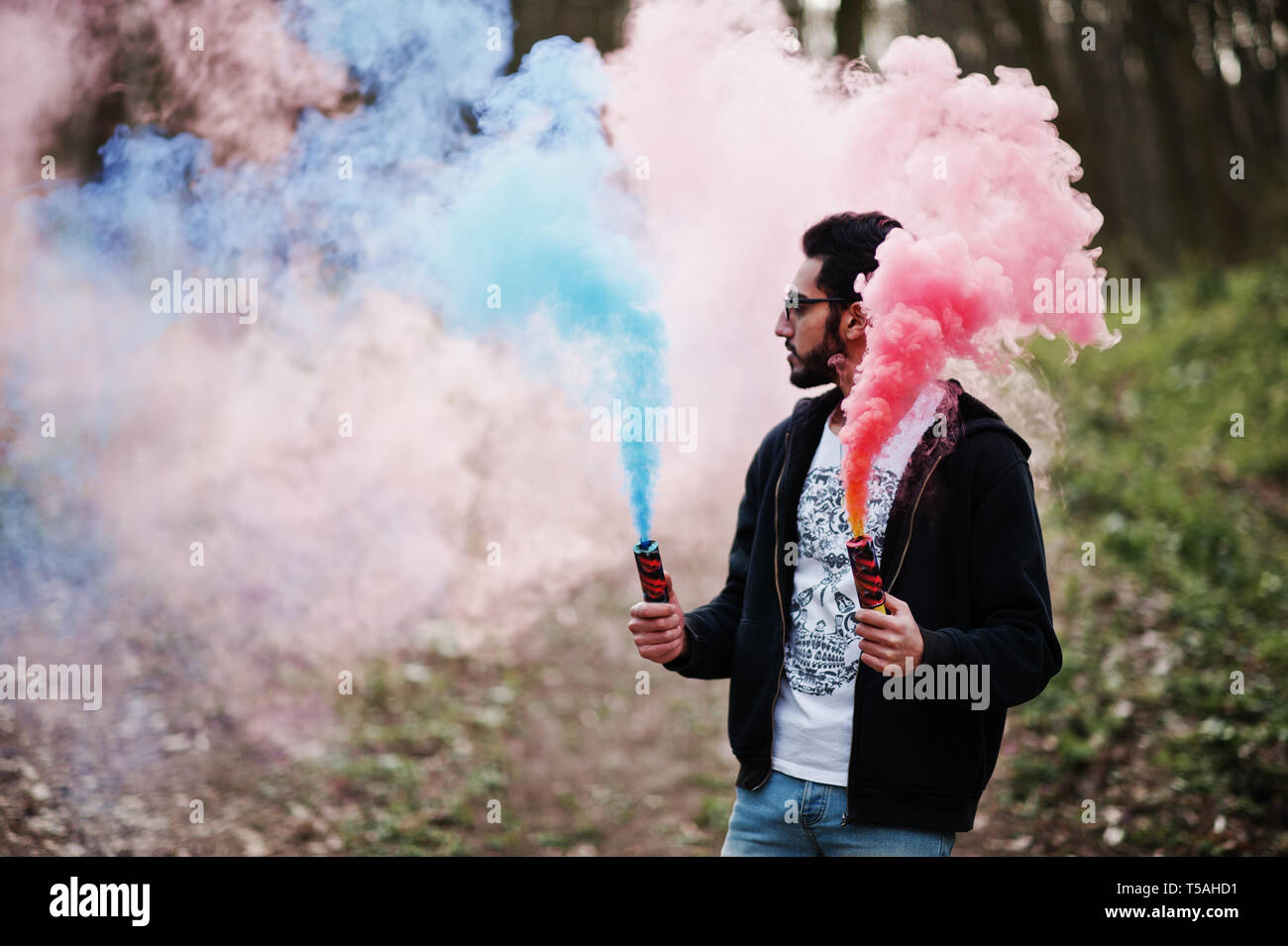 Street style arab man in eyeglasses hold hand flare with red and blue smoke  grenade bomb Stock Photo - Alamy