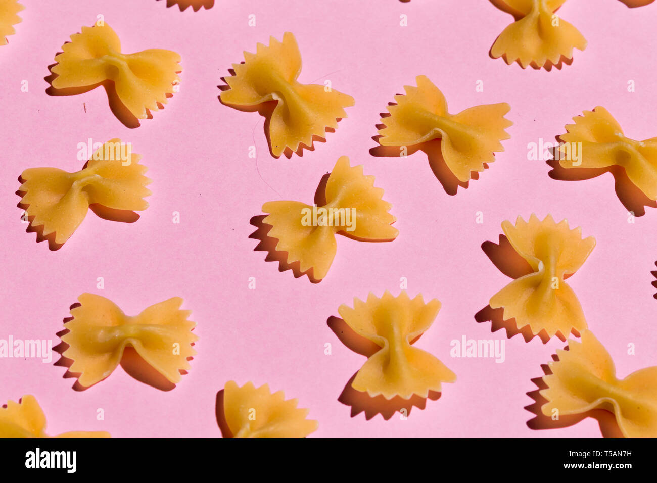 bow tie pasta isolated on pink background. top view Stock Photo - Alamy