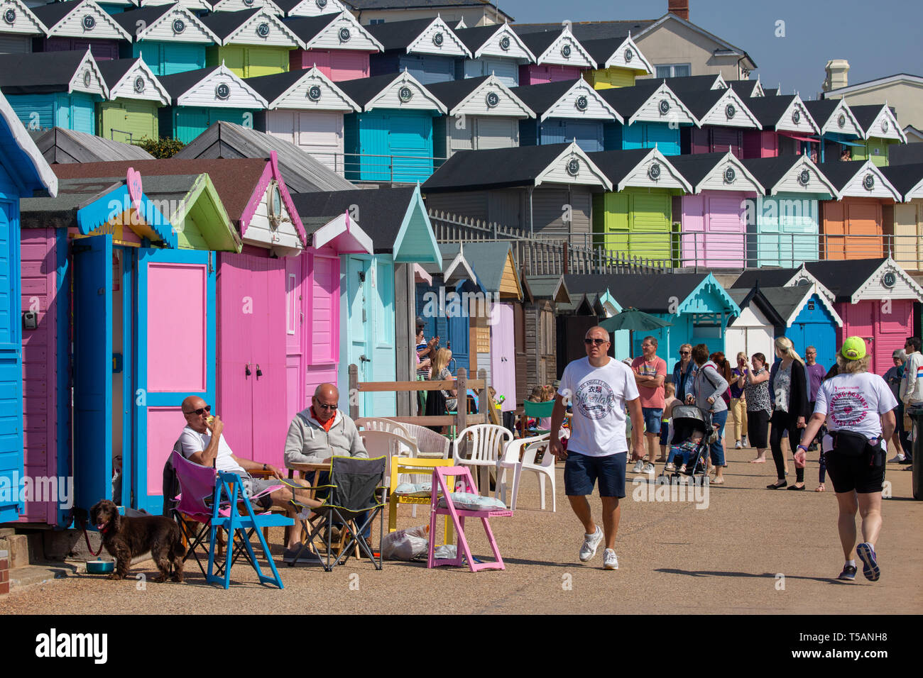 Picture dated April 21st shows people out on the beach and promenade by the colourful beach huts in Walton-on-the-Naze,Essex,on Easter Sunday afternoon and making the most on the hot weather. Stock Photo