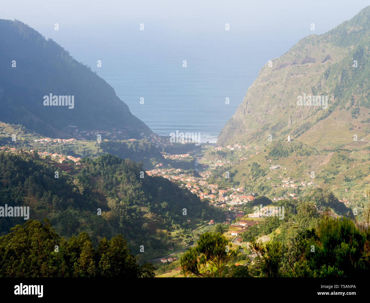 View of a valley in Madeira island, Portugal, with the Atlantic Ocean in the background. Stock Photo
