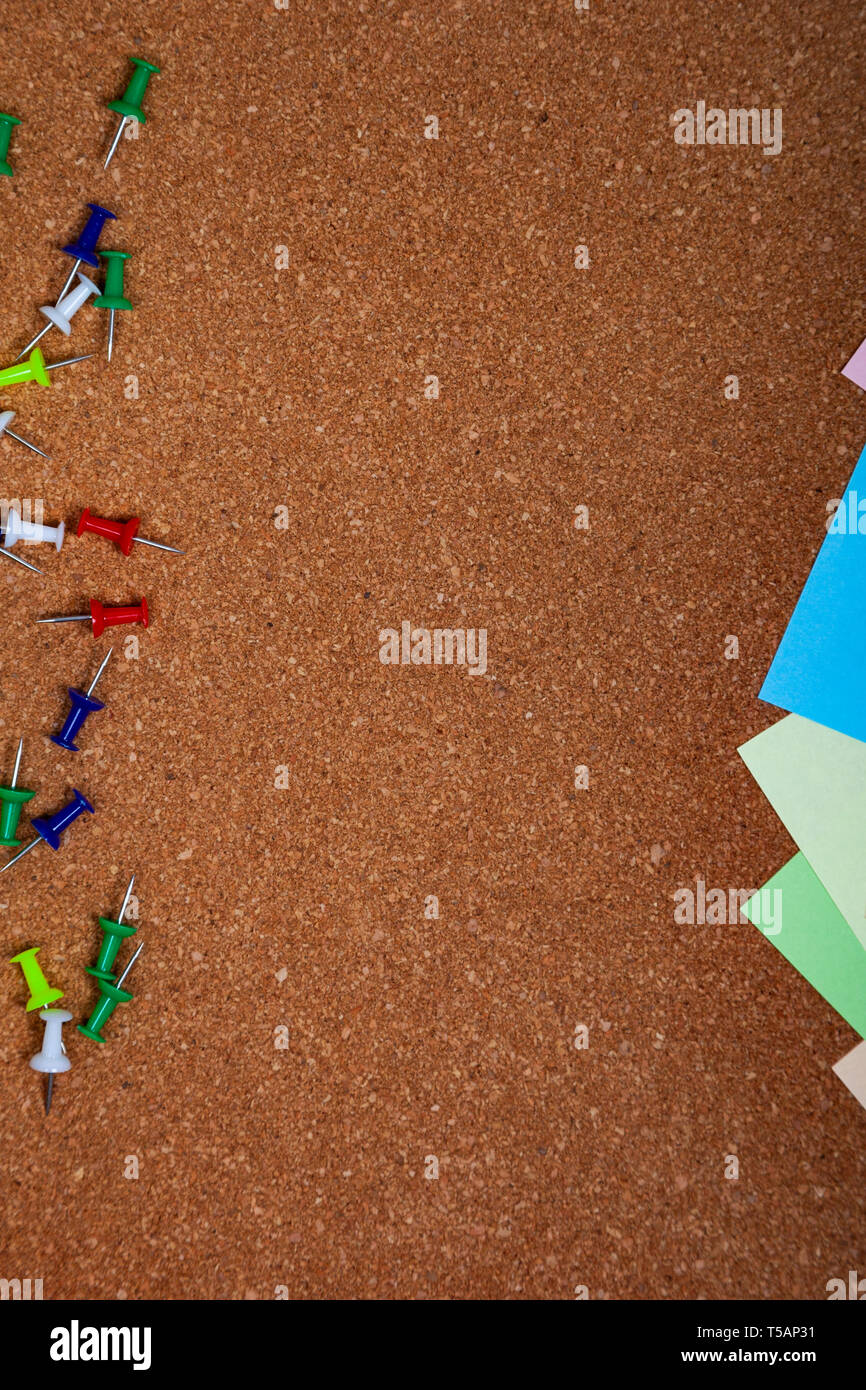 Corkboard with notes. Colored paper on corkboard. Stock Photo