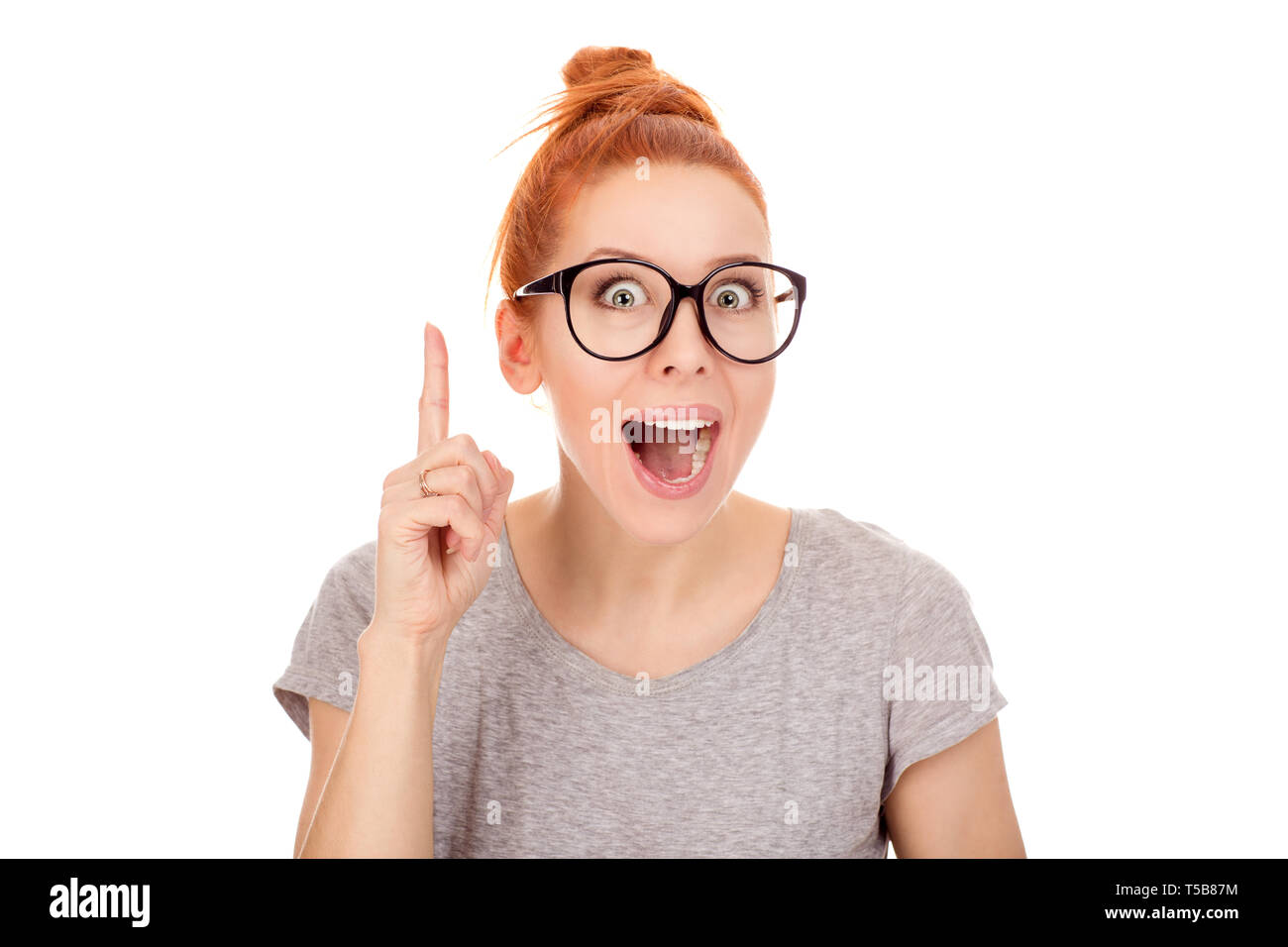Closeup portrait intelligent excited young woman in gray shirt who just came up with idea aha isolated white wall background with copy space. Positive Stock Photo