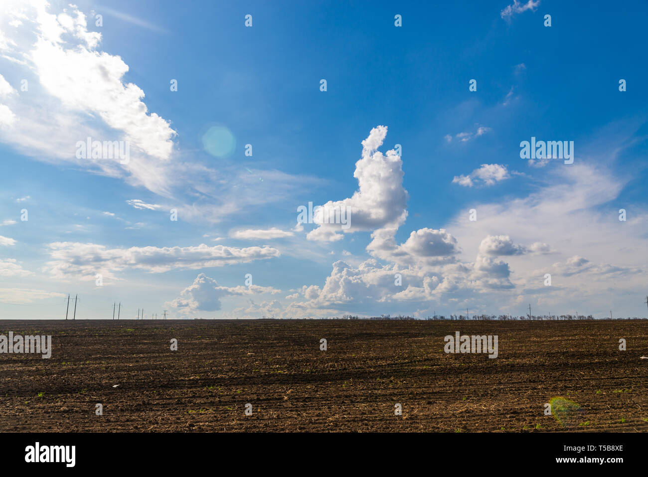 black agriculture field and blue sky with clouds Stock Photo - Alamy