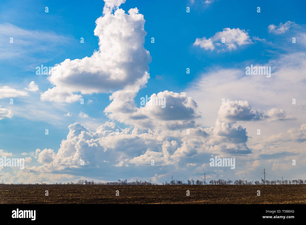 black agriculture field and blue sky with clouds Stock Photo - Alamy