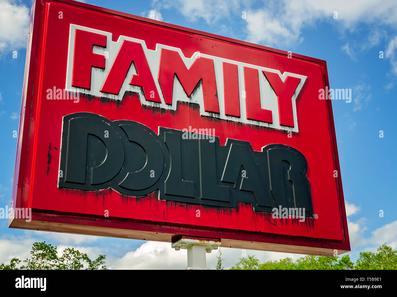 A Family Dollar sign is marked with black paint after the store’s closure,  April 19, 2019, in Bayou La Batre, Alabama. Stock Photo