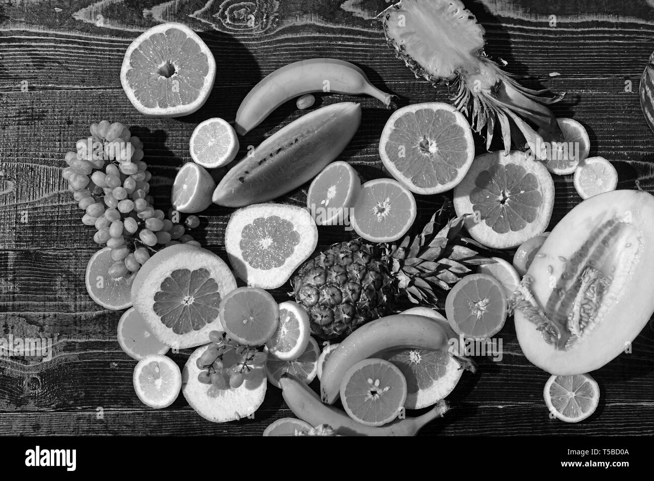 Juicy and colorful fresh seasonal fruit arranged on wooden table Stock Photo