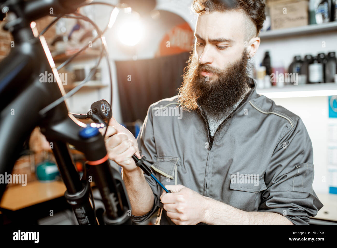 Repairman pumping shock absorber of the mountain bike in the